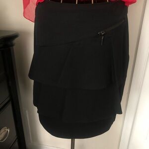 Black skirt with layered ruffles across the front and zip pocket in the front